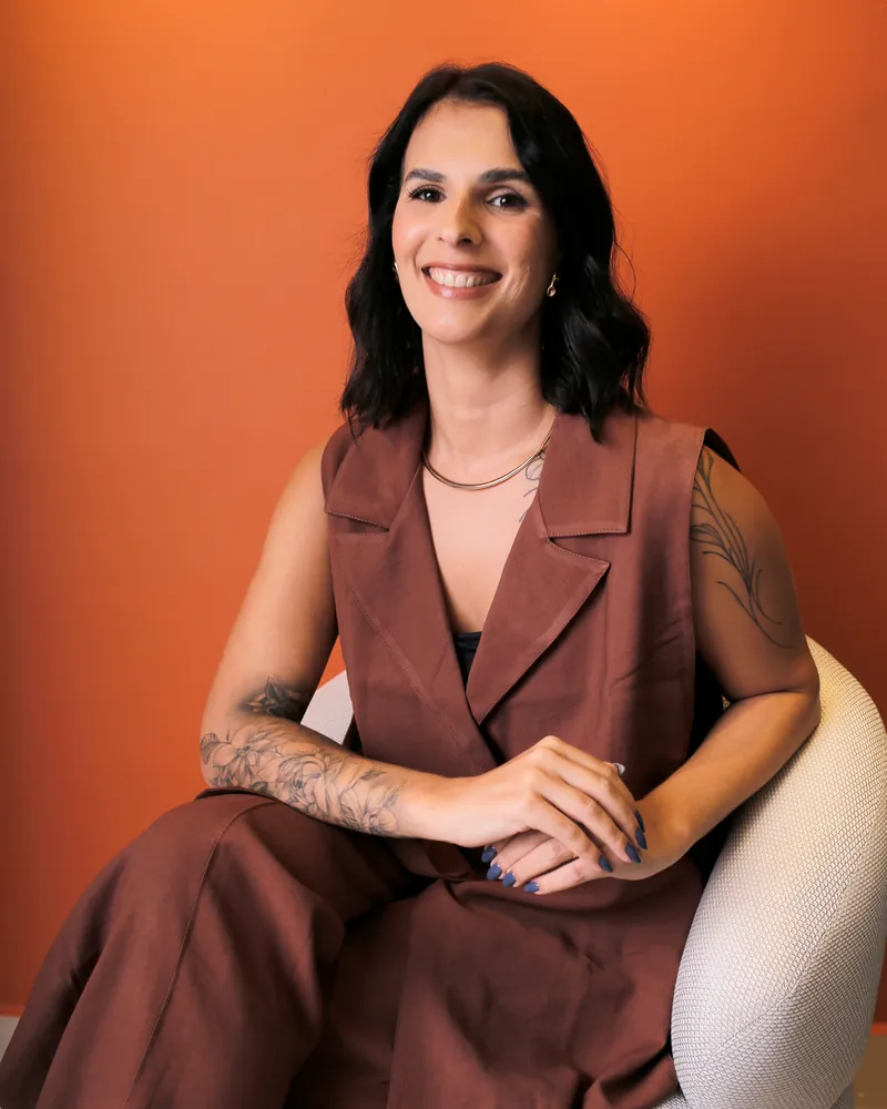 Karin Barbosa, arquiteta, sorrindo em seu escritório